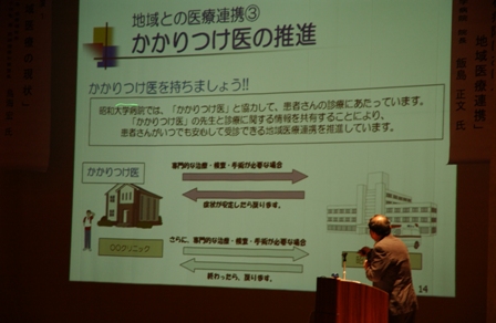 昭和大学病院長　飯島正文氏による『地域の中核病院における地域医療連携』について、スライドを用いて講演する様子。