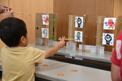 自分で作った割りばし鉄砲で遊んでいるの写真