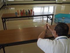 わりばし鉄砲で的を狙っている様子