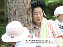 木に体を寄せ、木のぬくもりを感じている様子の写真1