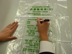 資源物指定袋へ氏名を記入している様子の画像