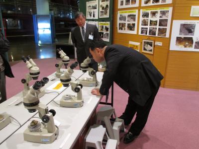 顕微鏡で鉱物を観察する市長の画像