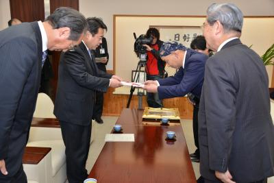 ご親族から寄附の目録を贈呈される市長の画像