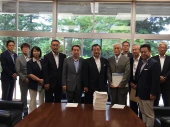 垣内県議会議長、諏訪副議長に署名を提出する様子の画像